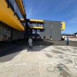 Robotnicy pracują nad izolacjami tarasów w nowoczesnym budynku.