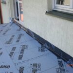 Na balkonie widać materiał używany do uszczelniania betonu pod oknem.