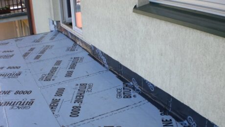 Na balkonie widać materiał używany do uszczelniania betonu pod oknem.