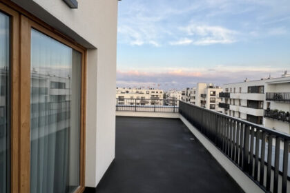 Nowoczesny balkon z dobrą izolacją, z widokiem na zabudowania.