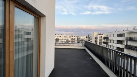 Nowoczesny balkon z dobrą izolacją, z widokiem na zabudowania.