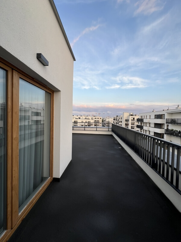 Nowoczesny balkon z dobrą izolacją, z widokiem na zabudowania.