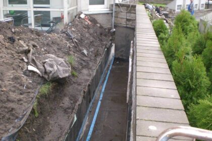 Prace budowlane obejmujące hydroizolacje tarasów przy budynku.