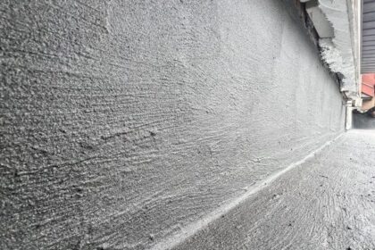 Izolacje przeciwwilgociowe na ścianie fundamentowej wykonane warstwą szarej masy hydroizolacyjnej.