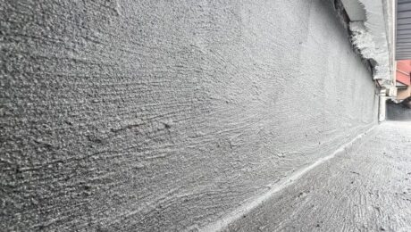 Izolacje przeciwwilgociowe na ścianie fundamentowej wykonane warstwą szarej masy hydroizolacyjnej.