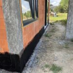 Hydroizolacja fundamentów w szeregowcu obejmuje głównie ścianę frontową i ogrodową; od wewnątrz stosuje się powłoki mineralne i iniekcje rys.