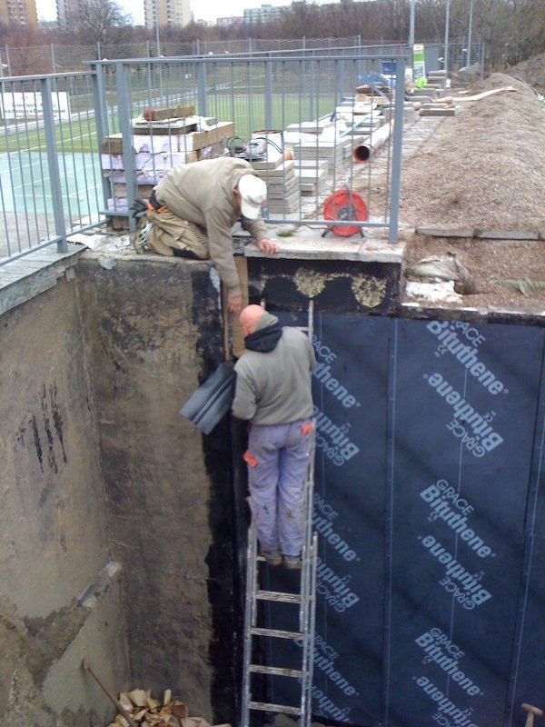Wykop przy ścianie fundamentowej starego domu prowadzony odcinkami