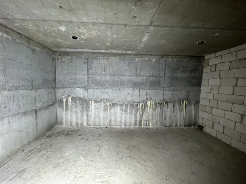 Betonowa piwnica po iniekcji - wypływy żywicy wzdłuż dolnej części ścian