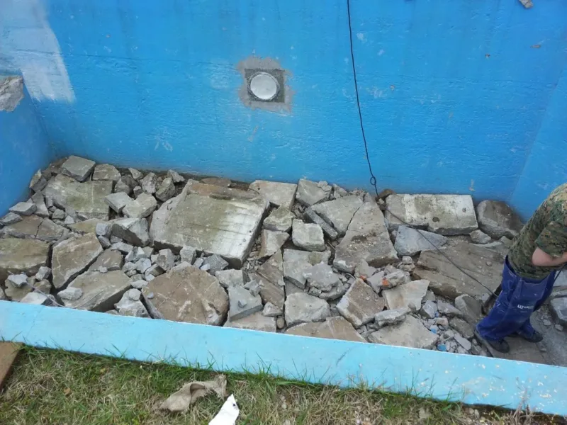 Skuty stary beton na dnie niecki basenu ogrodowego
