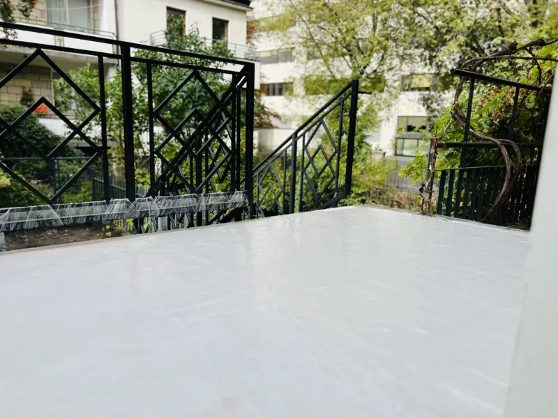 Balkon z ozdobną balustradą po nałożeniu białej powłoki hydroizolacyjnej