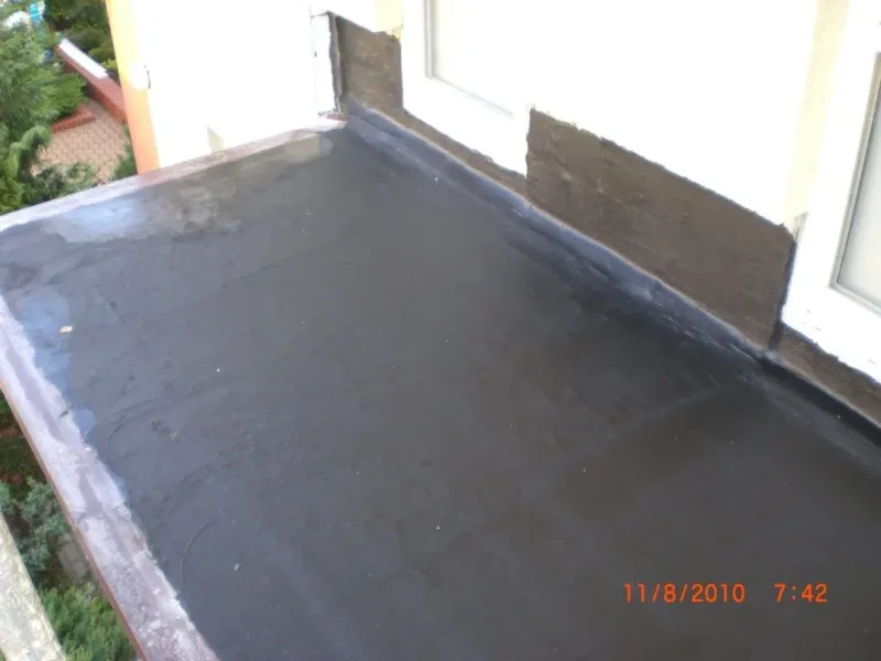 Balkon pokryty nową hydroizolacją przy drzwiach balkonowych