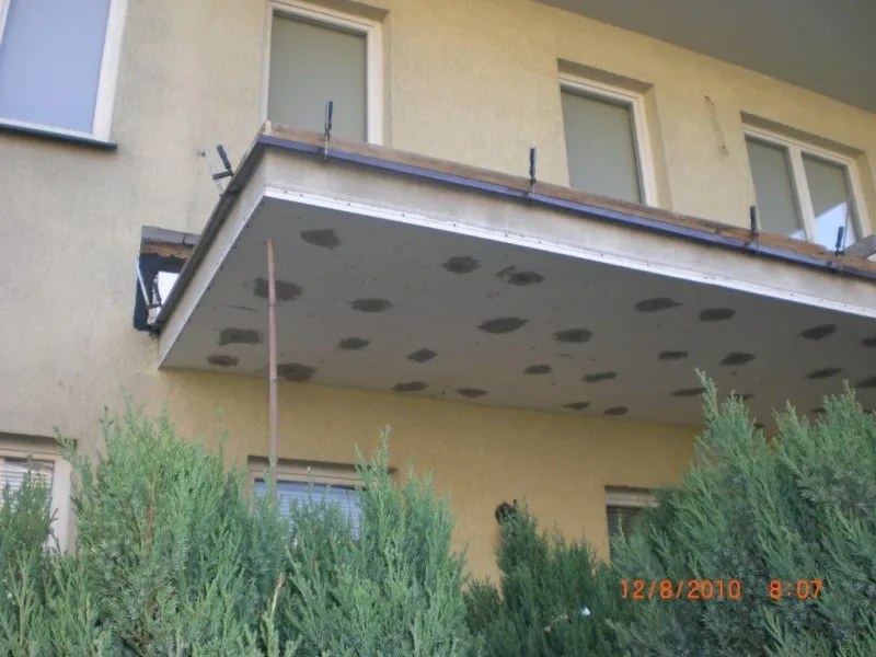 Płyta balkonowa od spodu z miejscowymi naprawami betonu