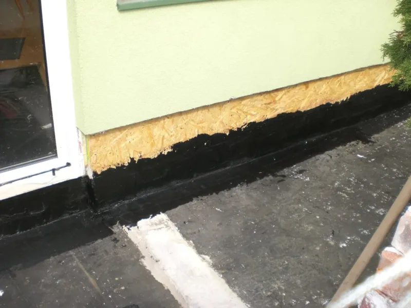 Narożnik tarasu z izolacją wywiniętą na ścianę i płytą OSB nad nią