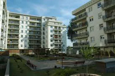 Zielony dziedziniec osiedla między budynkami z balkonami