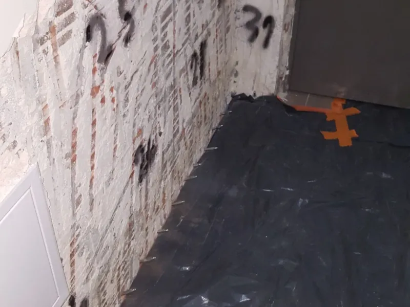 Narożnik z odbitym tynkiem i oznaczeniami markerem przed iniekcją