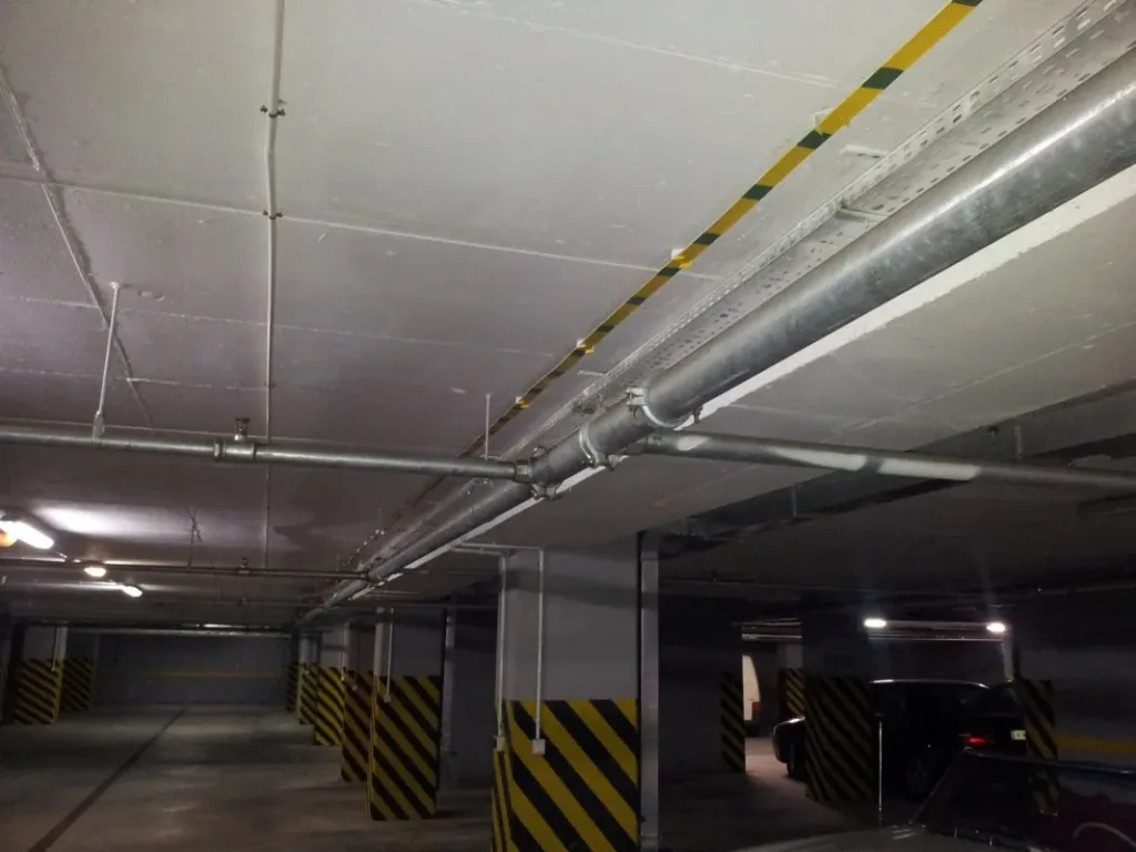 Garaż podziemny przed uszczelnieniem - instalacje pod stropem i miejsca postojowe