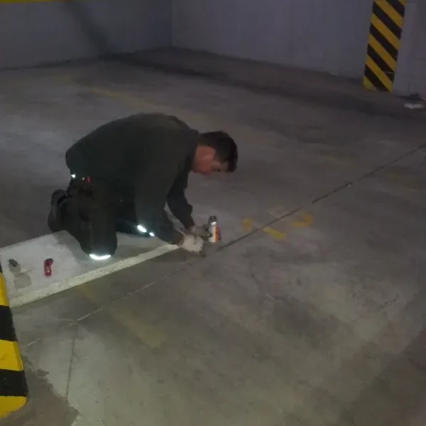 Uszczelnianie szczeliny w posadzce garażu przy oznakowanym słupie