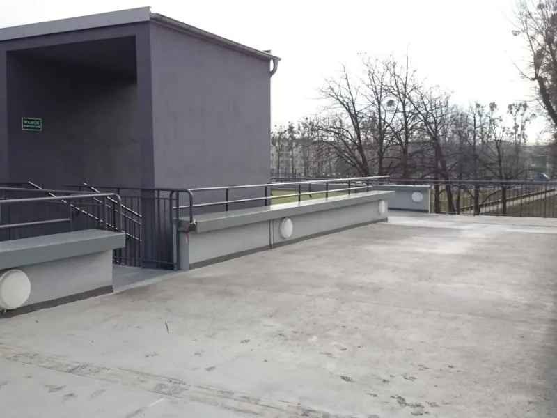 Taras z balustradami i wyjściem z klatki schodowej na obiekcie sportowym