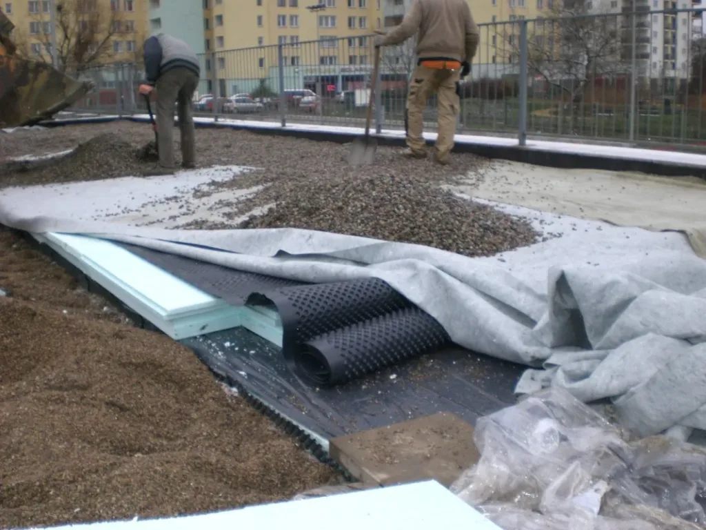 Warstwy na stropie: geowłóknina, płyty XPS i folia kubełkowa przed zasypaniem żwirem