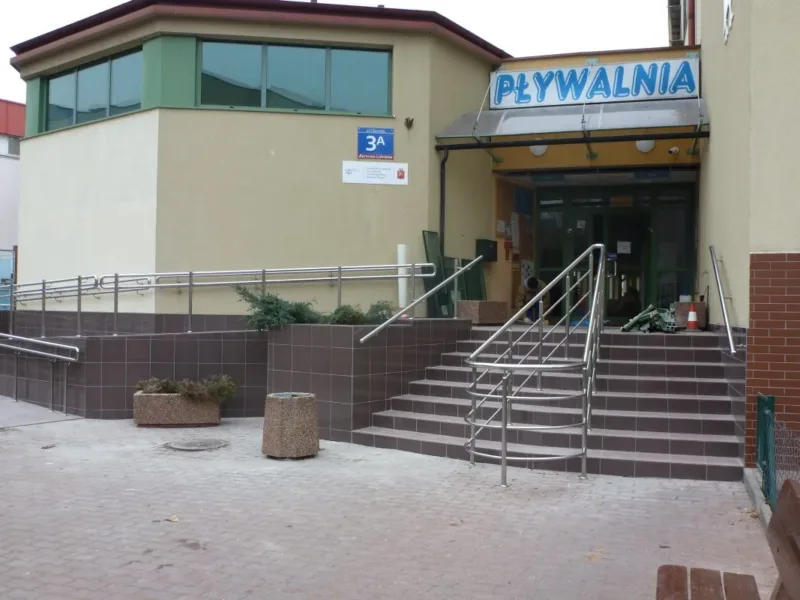 Wejście do budynku pływalni z tarasem i schodami