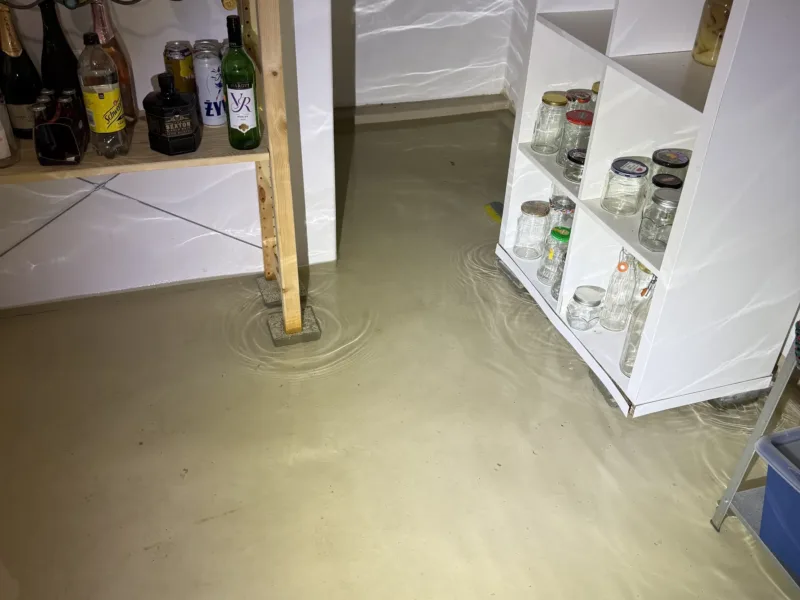 Zalane pomieszczenie - woda na podłodze między regałami